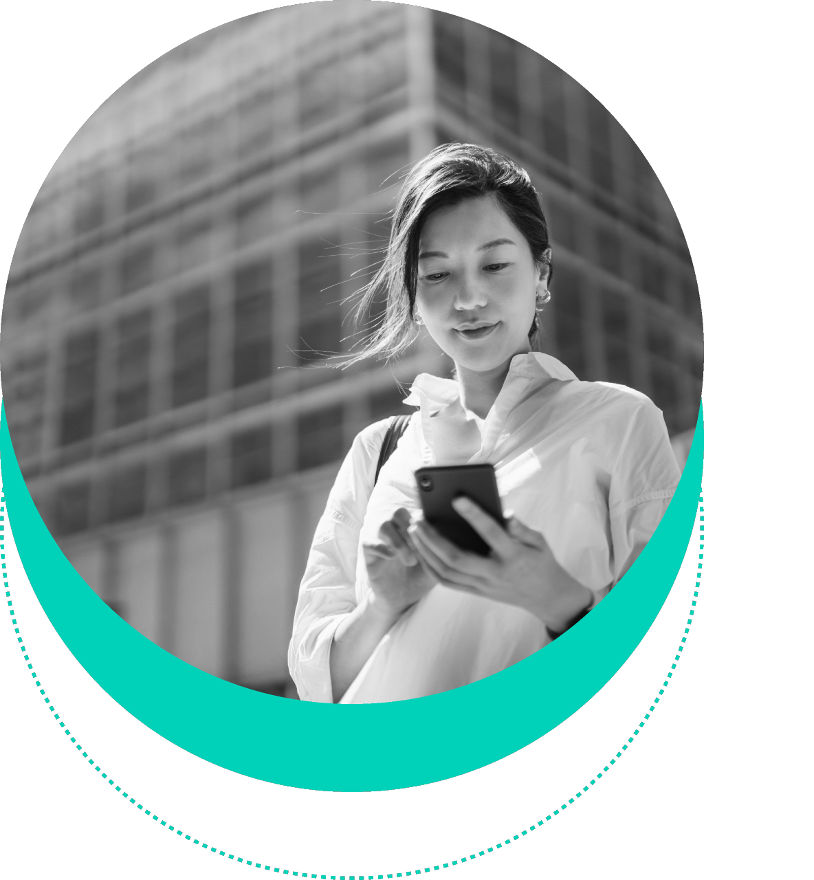 A person standing outdoors and looking at their phone, with a modern building in the background.