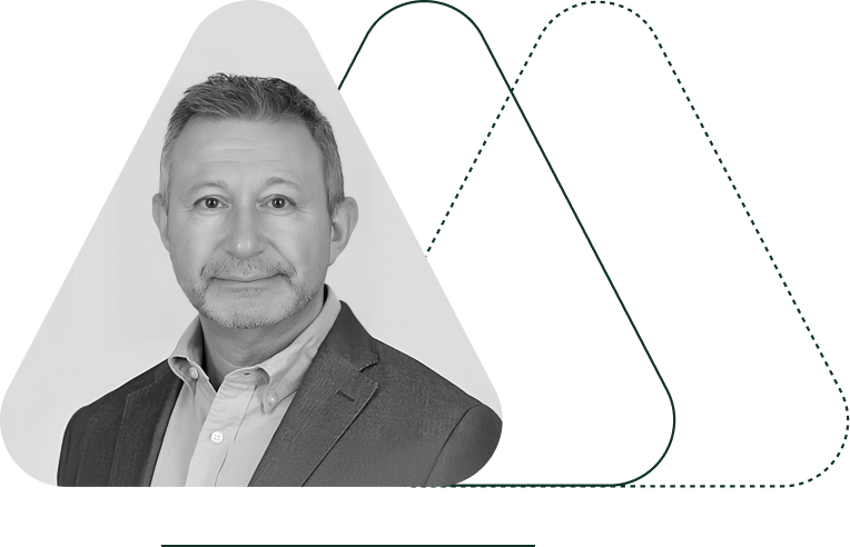 Black and white headshot of a man in a suit jacket and collared shirt, standing in front of an abstract geometric background, exuding confidence—ideal for promoting monetization solutions.